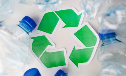 Logo vert de recyclage entouré de bouteilles plastiques vides