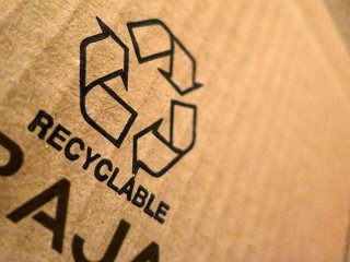 Gros plan sur un packaging écologique avec le logo du recyclage et RAJA